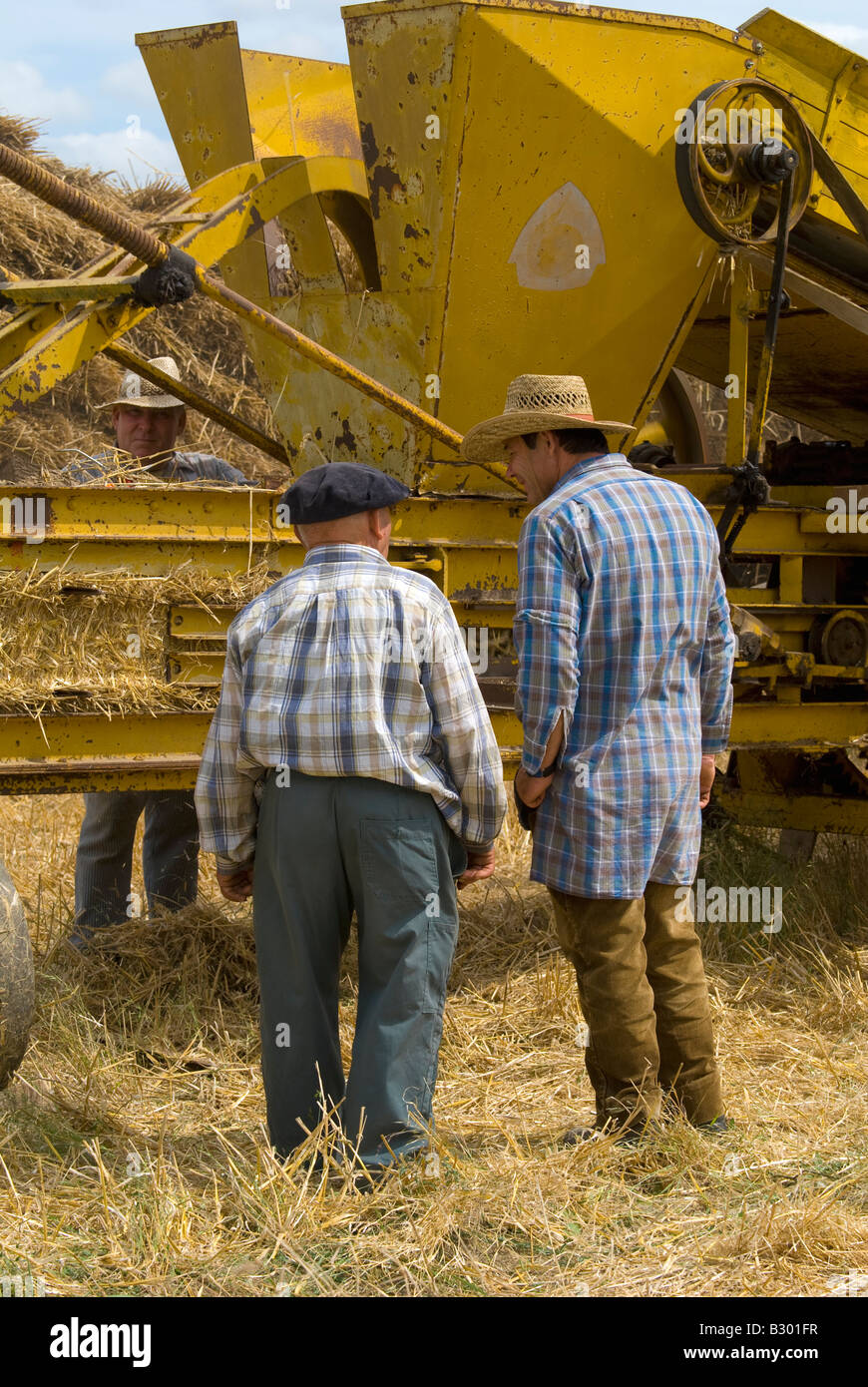 French farmers working on old straw baler machine at agricultural show