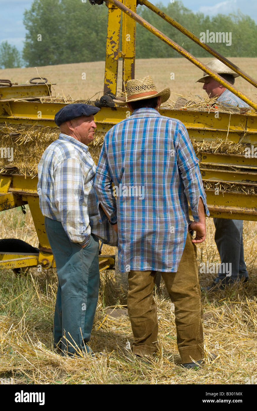 French farmers working on old straw baler machine at agricultural show, Indre, France. Stock Photo