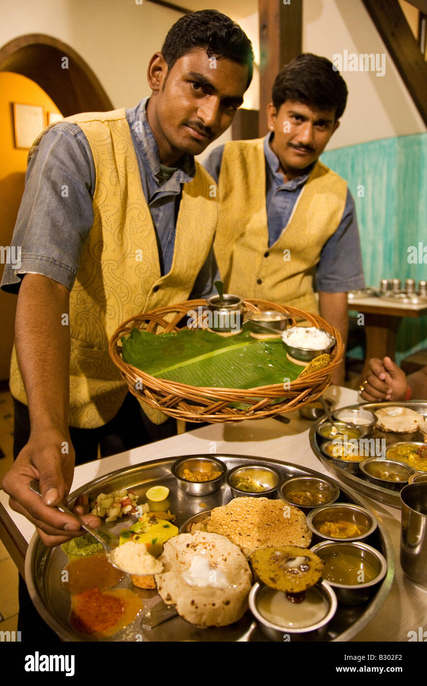 Two waiters serve a traditional Gujarati Thali meal. Stock Photo