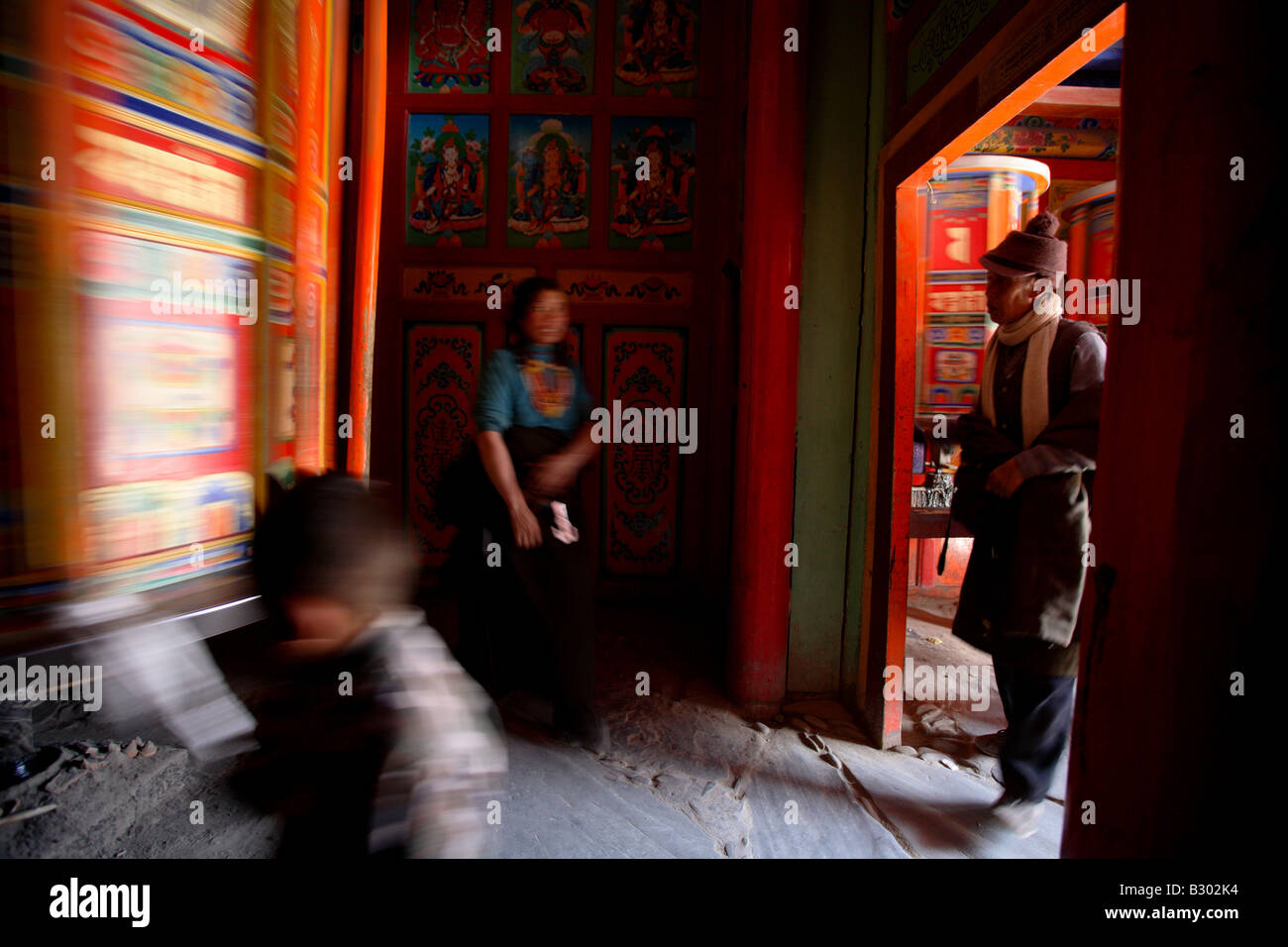 Tibetan Buddhist encircle a big prayer wheel at  Labrang monastery in Xiahe county / Gansu province Stock Photo