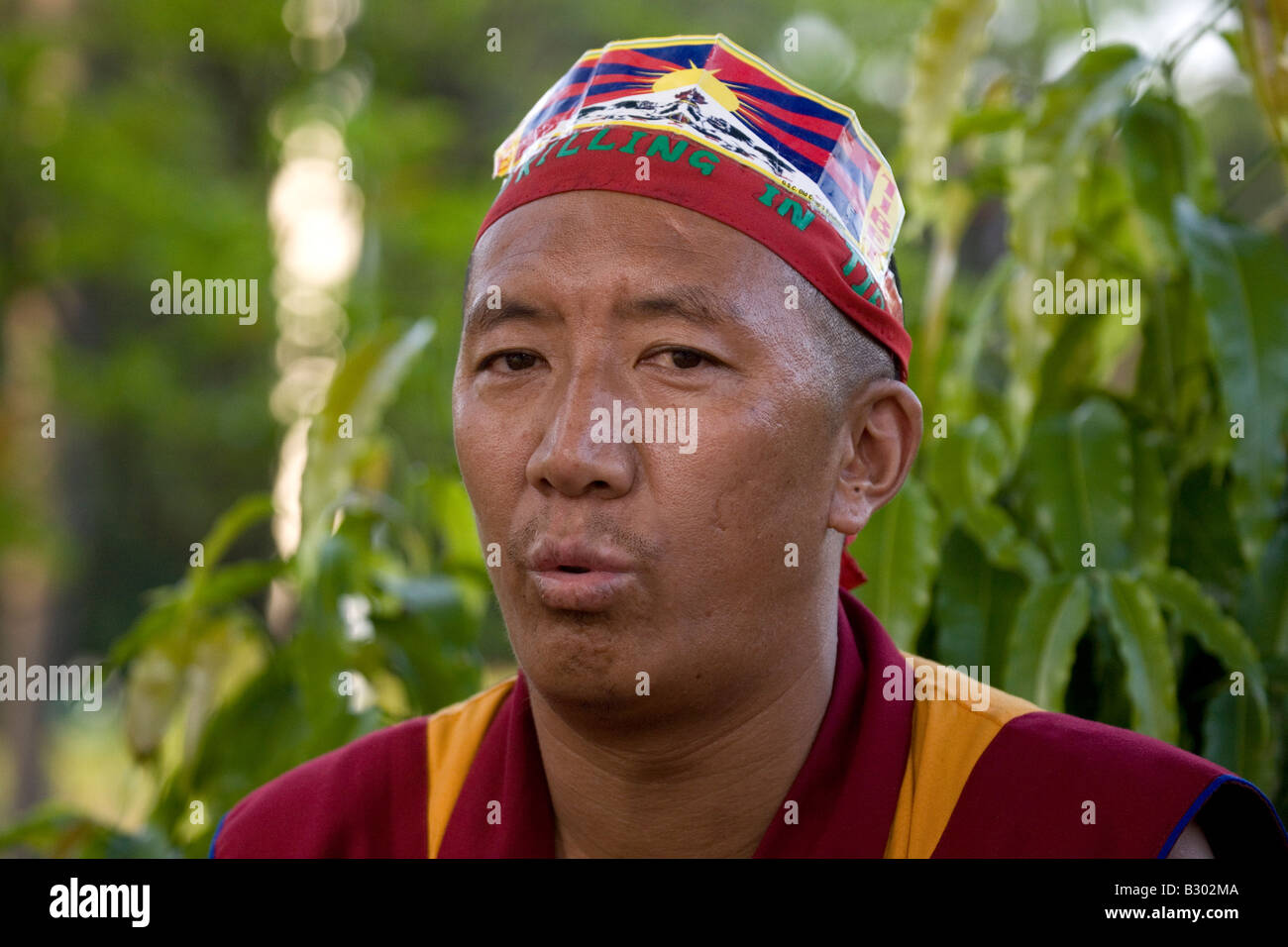 A monk wears a headband with a slogan that states 'Stop Killing in Tibet'. Stock Photo