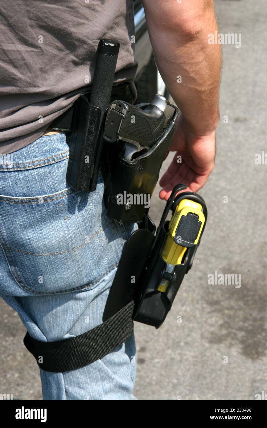 Plainclothes police detective armed with handgun baton and tazer strapped to leg Stock Photo
