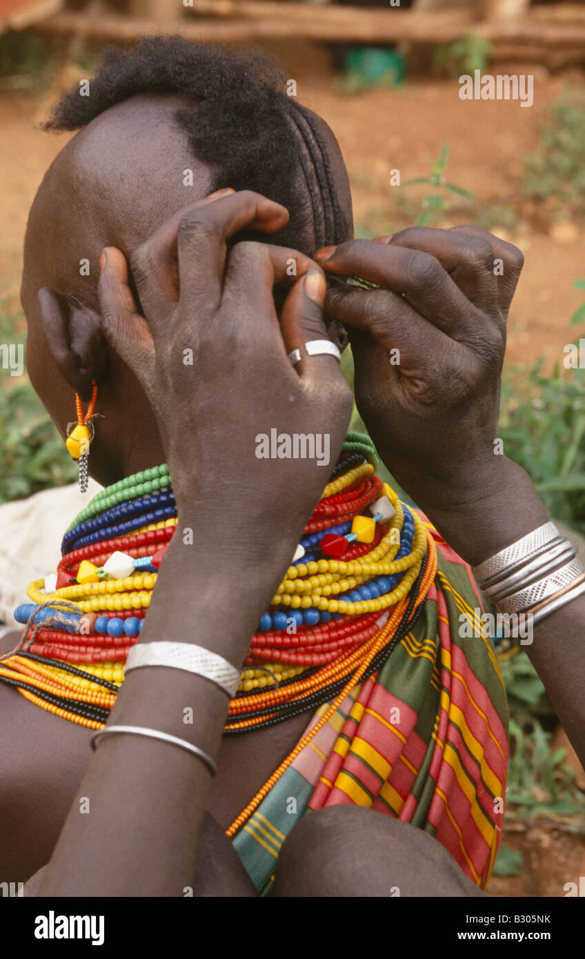 Karamojong ethnic women braiding hair. Karamoja, Uganda. Stock Photo