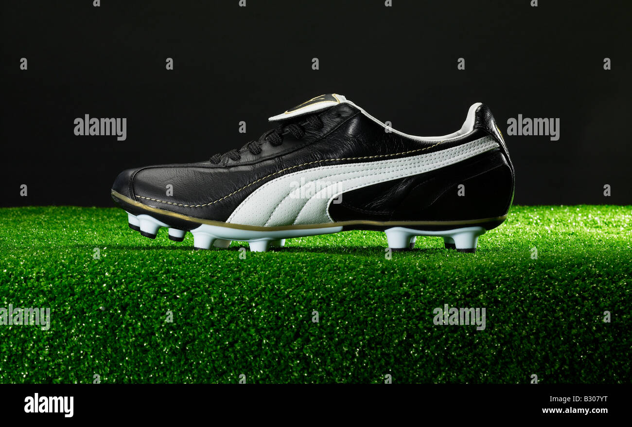 Football boot on green fake grass Stock Photo Alamy