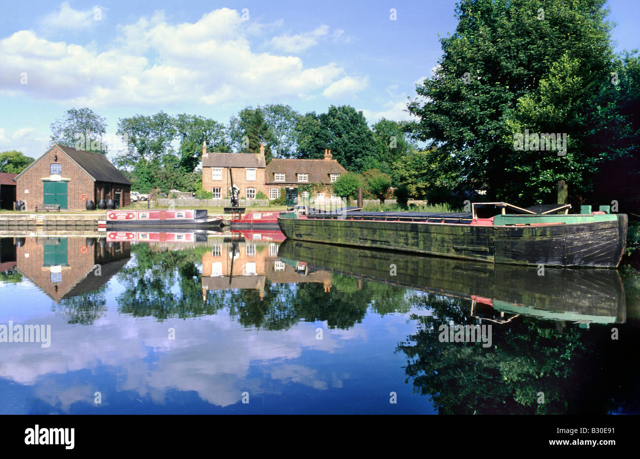 Narrow boats and barge moored at Dapdune Wharf, River Wey Navigation, Guildford, Surrey Stock Photo