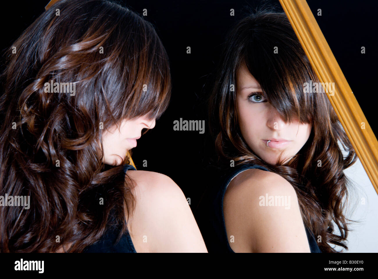 Brunette teenage girl looking in mirror Stock Photo - Alamy