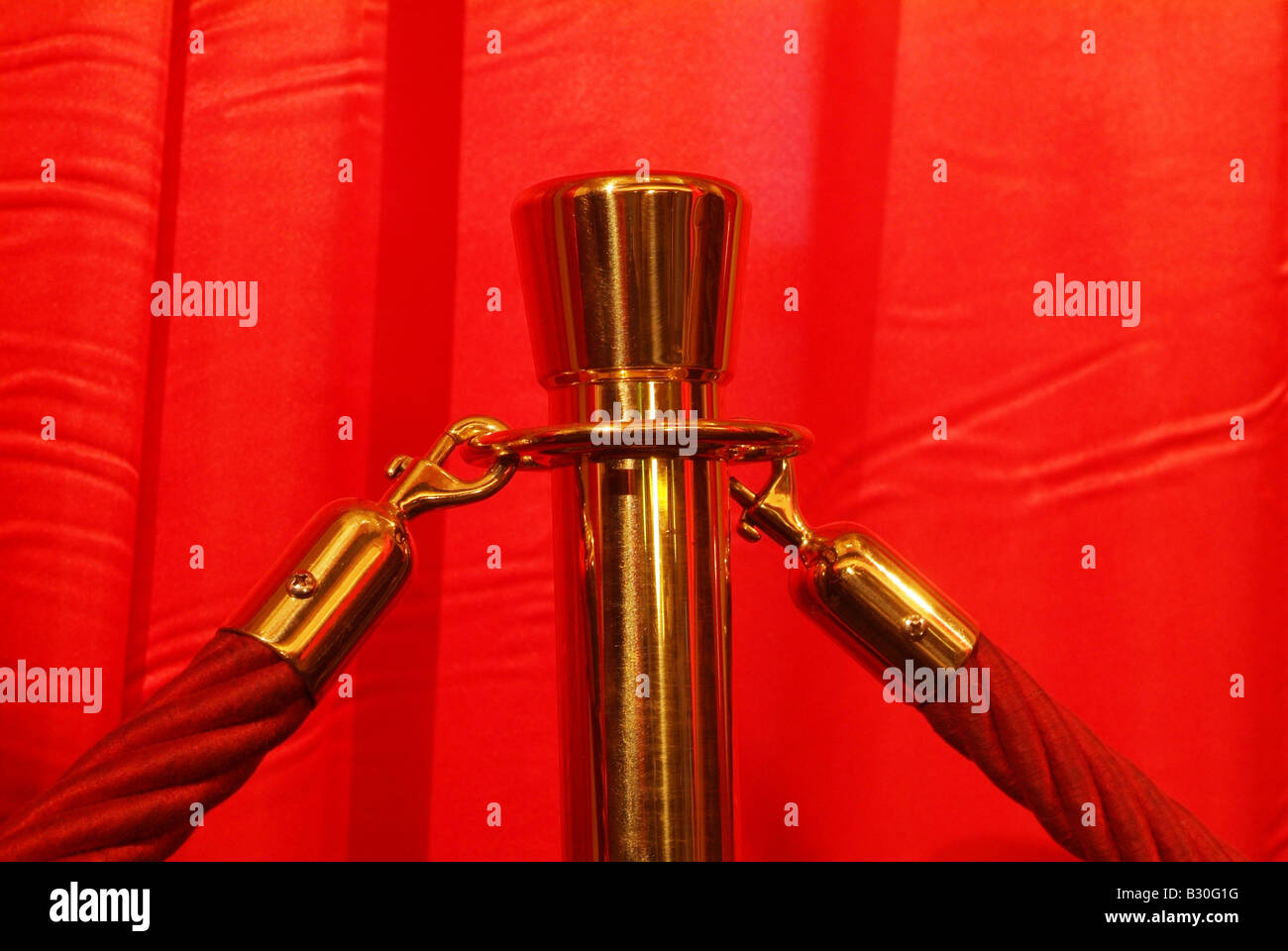Red cords on a gilded pole Stock Photo