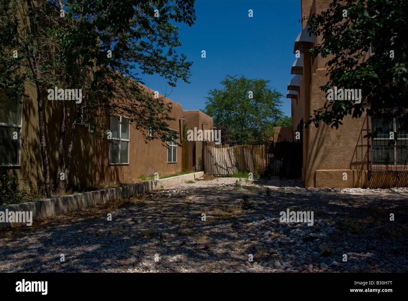 The plank fenced backyard of a residential house built in the Pueblo Revival Style in Albuquerque Stock Photo