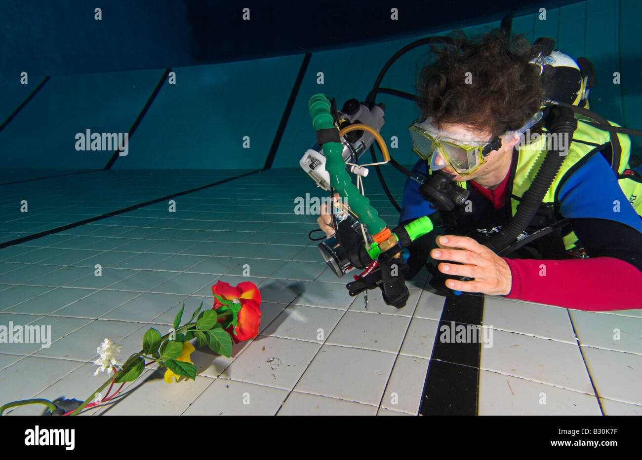 Woman scuba diver practices underwater photography in swimming pool Stock Photo