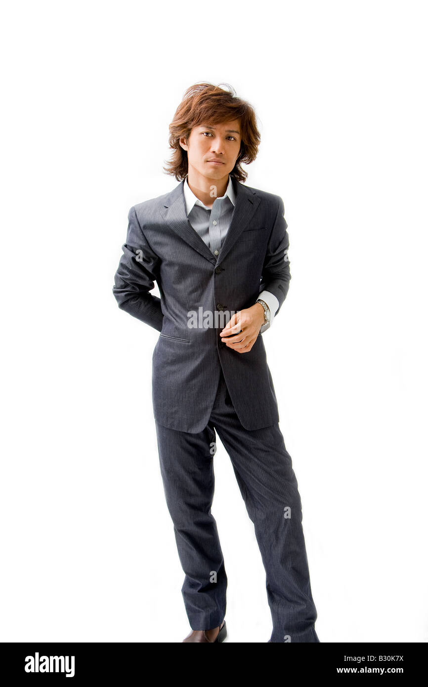 Young Asian business man dressed in a gray pinstripe suit with hand on back and button isolated Stock Photo