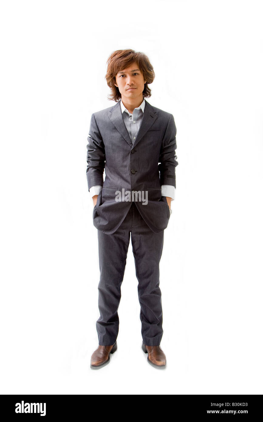 Young Asian business man dressed in a gray pinstripe suit with hands in pockets isolated Stock Photo