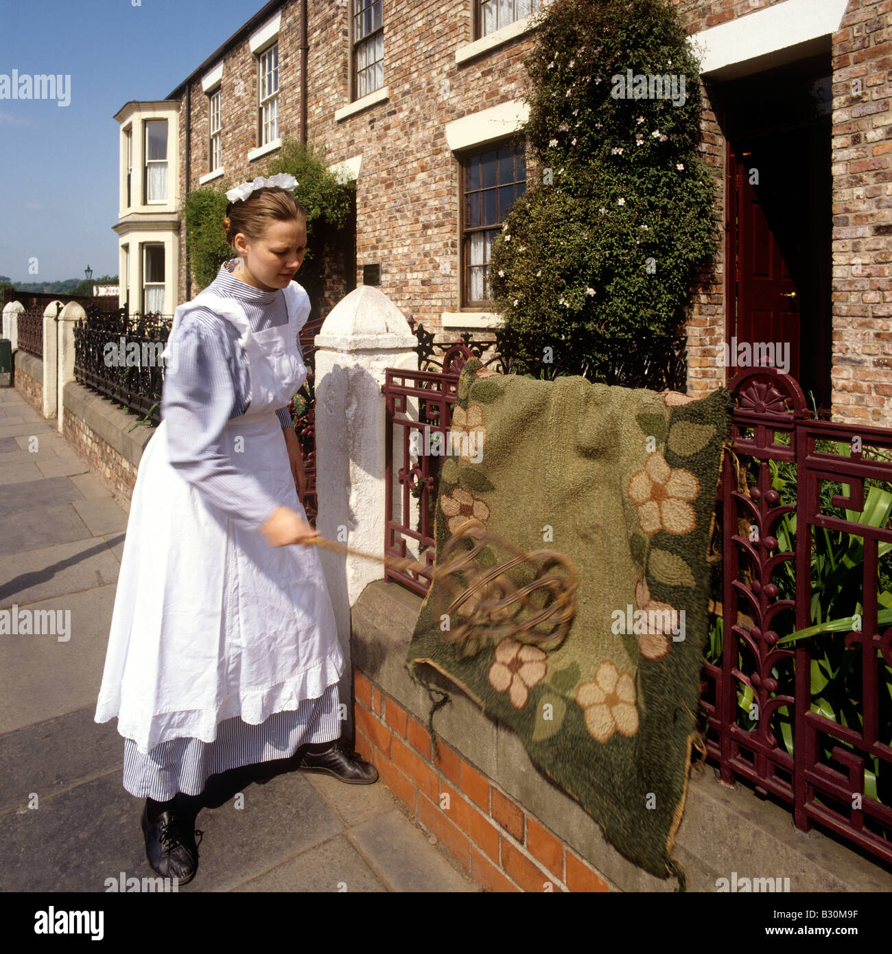 UK England County Durham Beamish Open Air Museum Alison Telfer maid beating a carpet Stock Photo