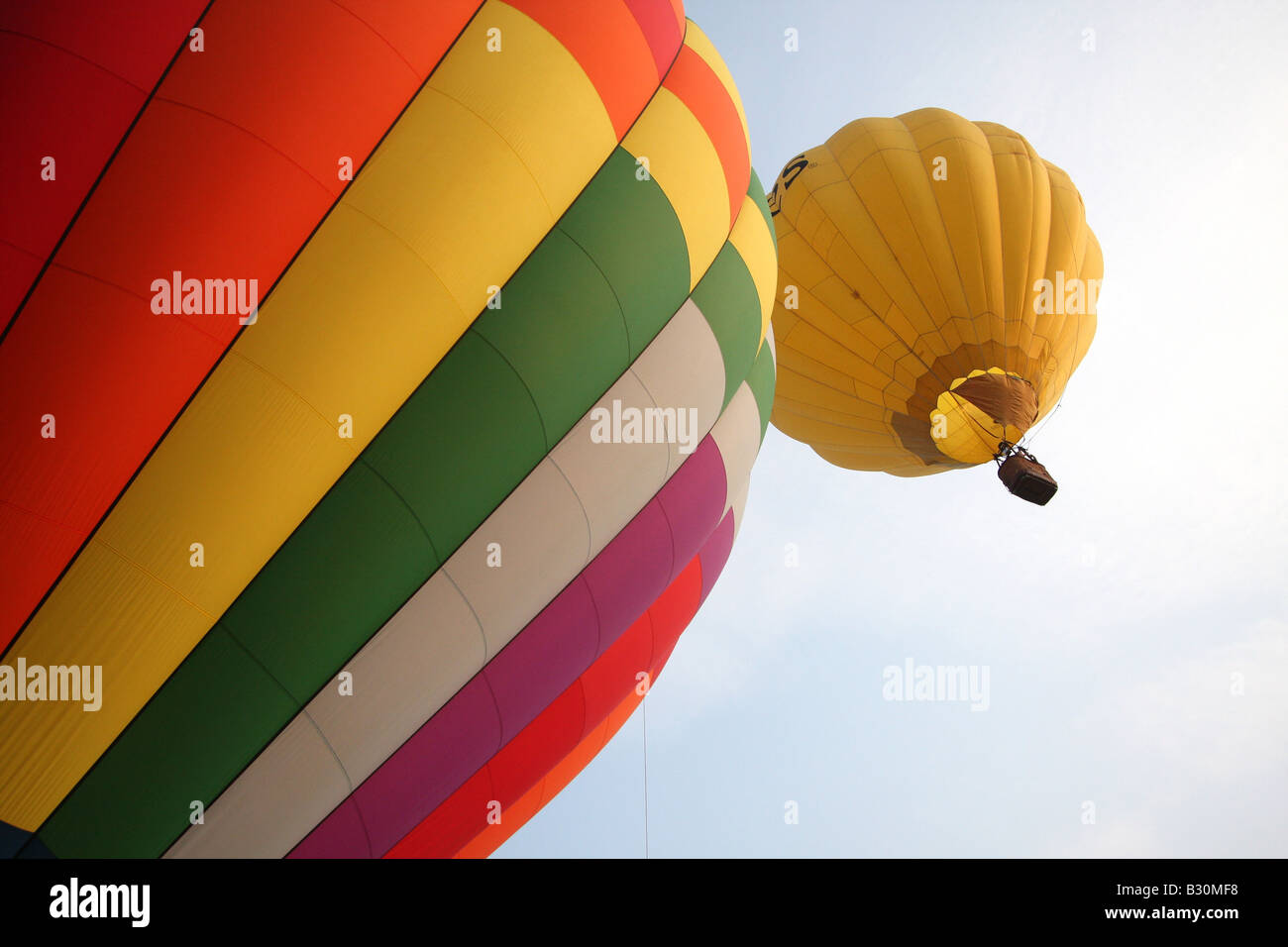 Brightly-colored hot air balloons float in the sky in early-morning ...