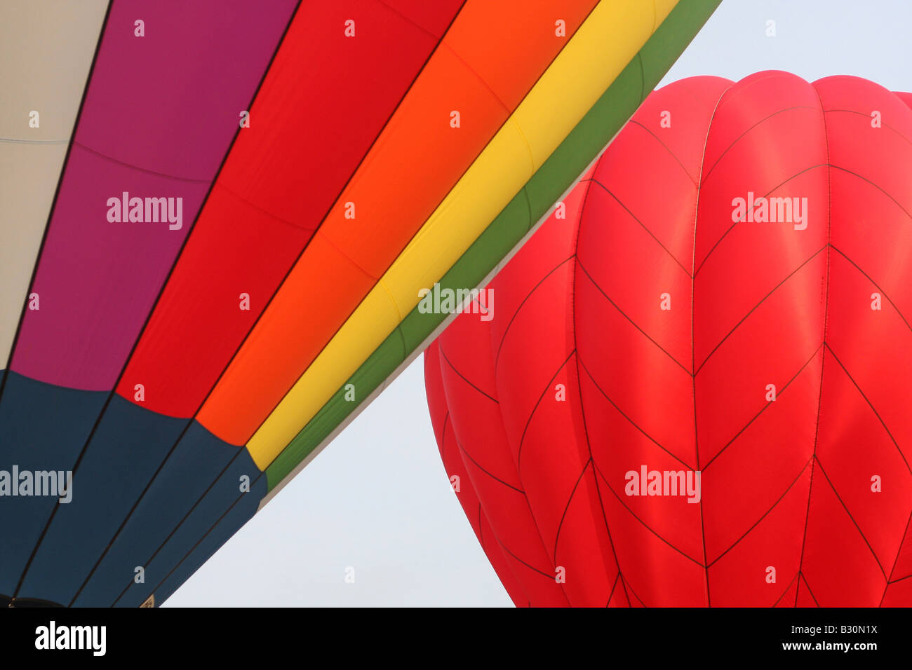 Brightly-colored hot air balloons float in the sky in early-morning ...