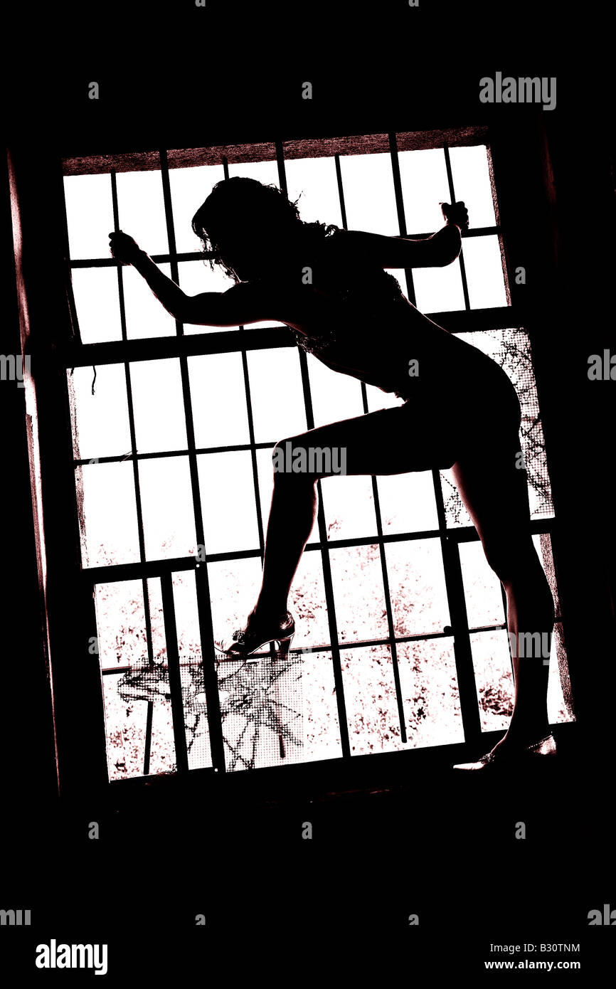 young woman climbing on window Stock Photo Alamy