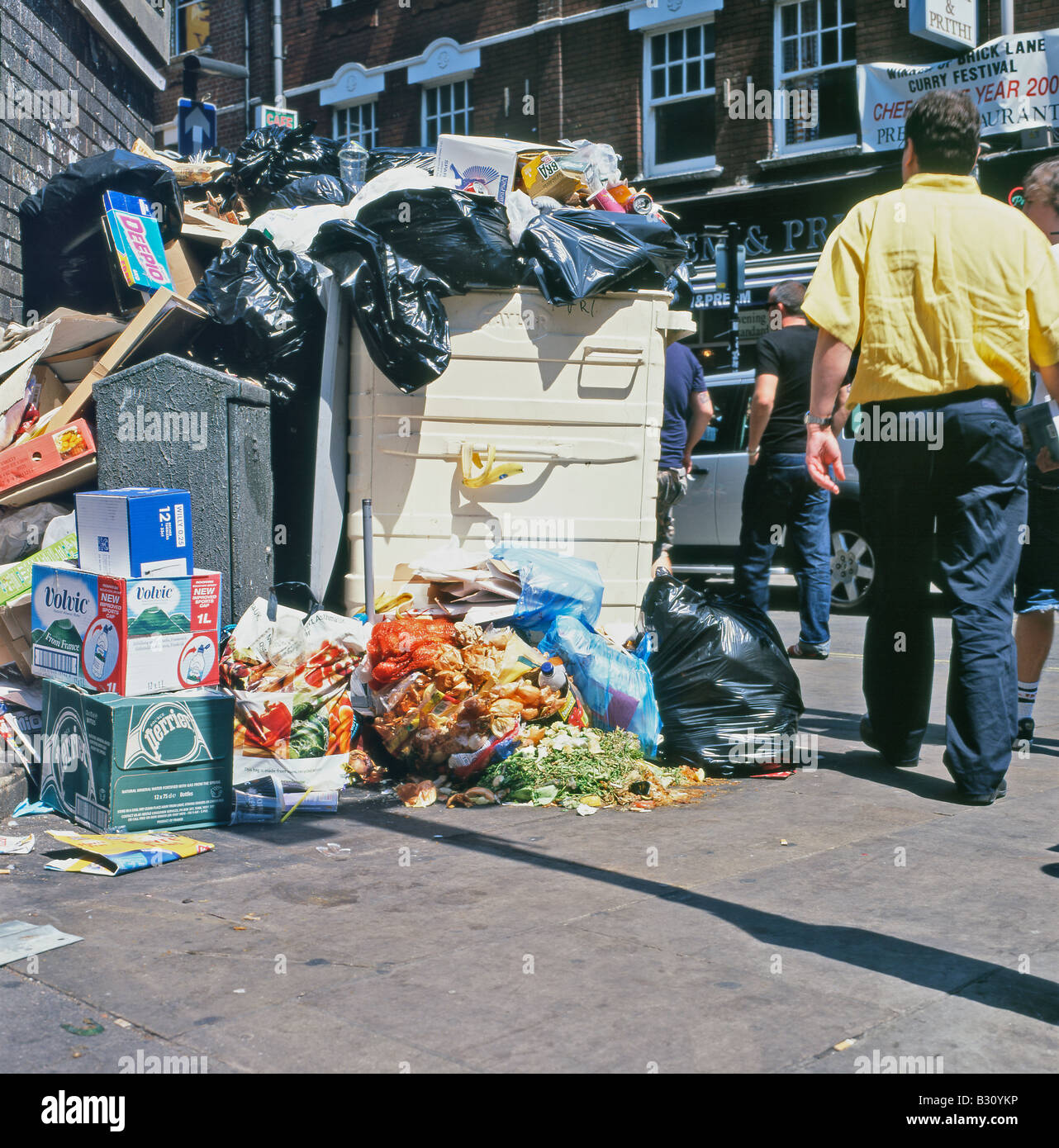 Rubbish spilling out of a bin on the pavement on a Sunday morning in Brick Lane London England UK  KATHY DEWITT Stock Photo