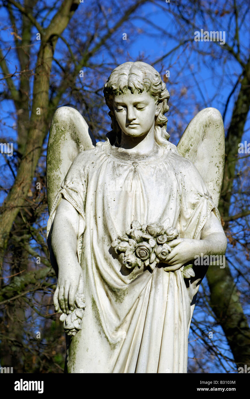 white marble angel sculpture against a blue sky Stock Photo