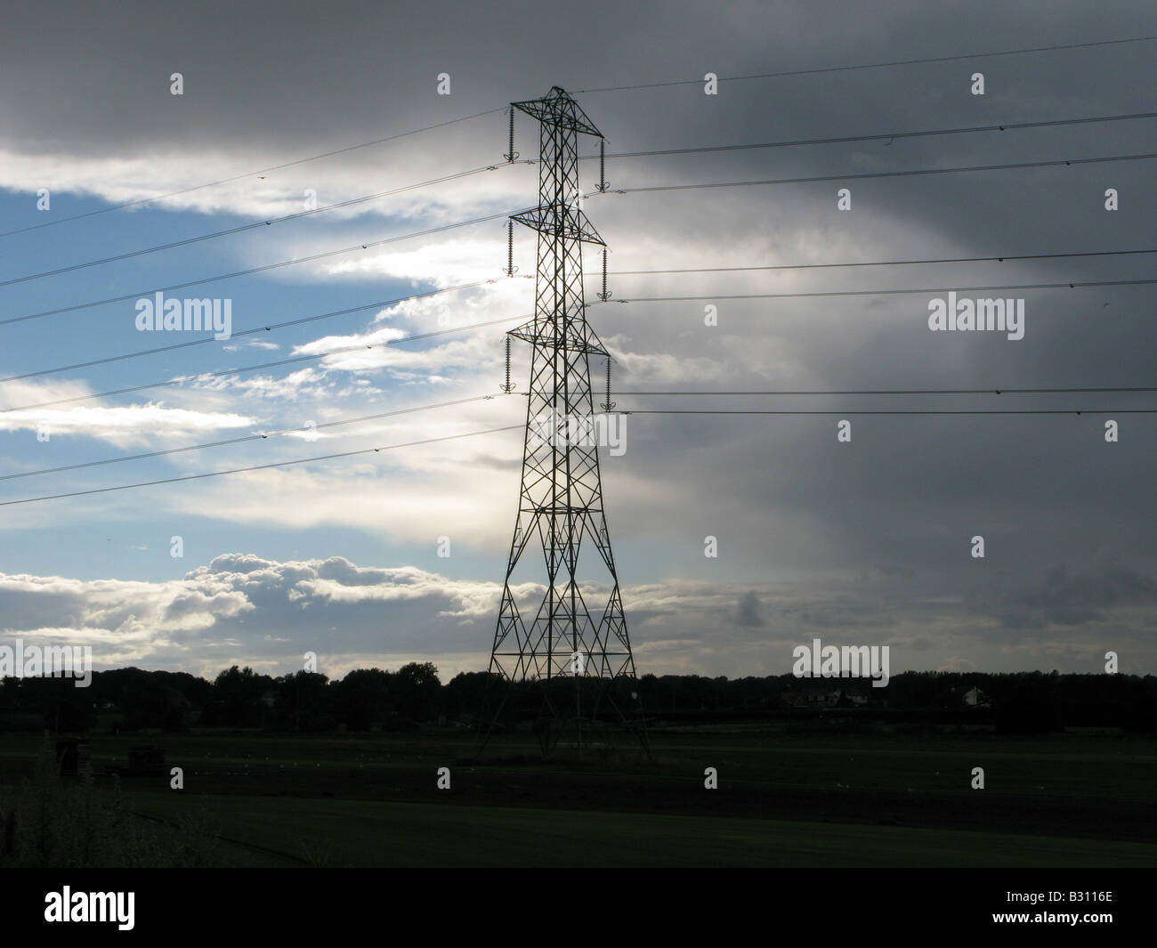 Electricity pylon with storm clouds and blue sky background Stock Photo ...