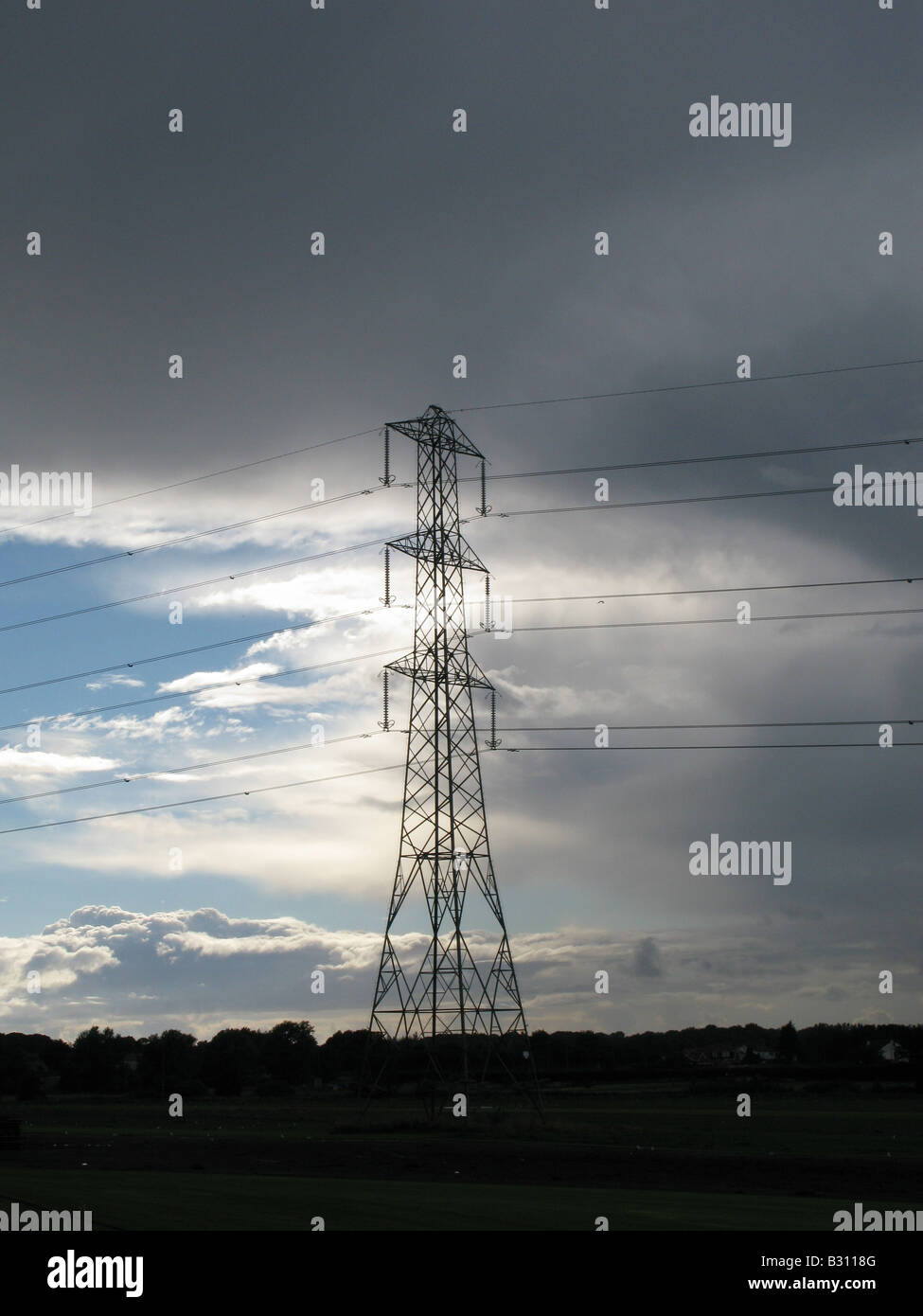 Electricity pylon with storm clouds and blue sky background Stock Photo ...