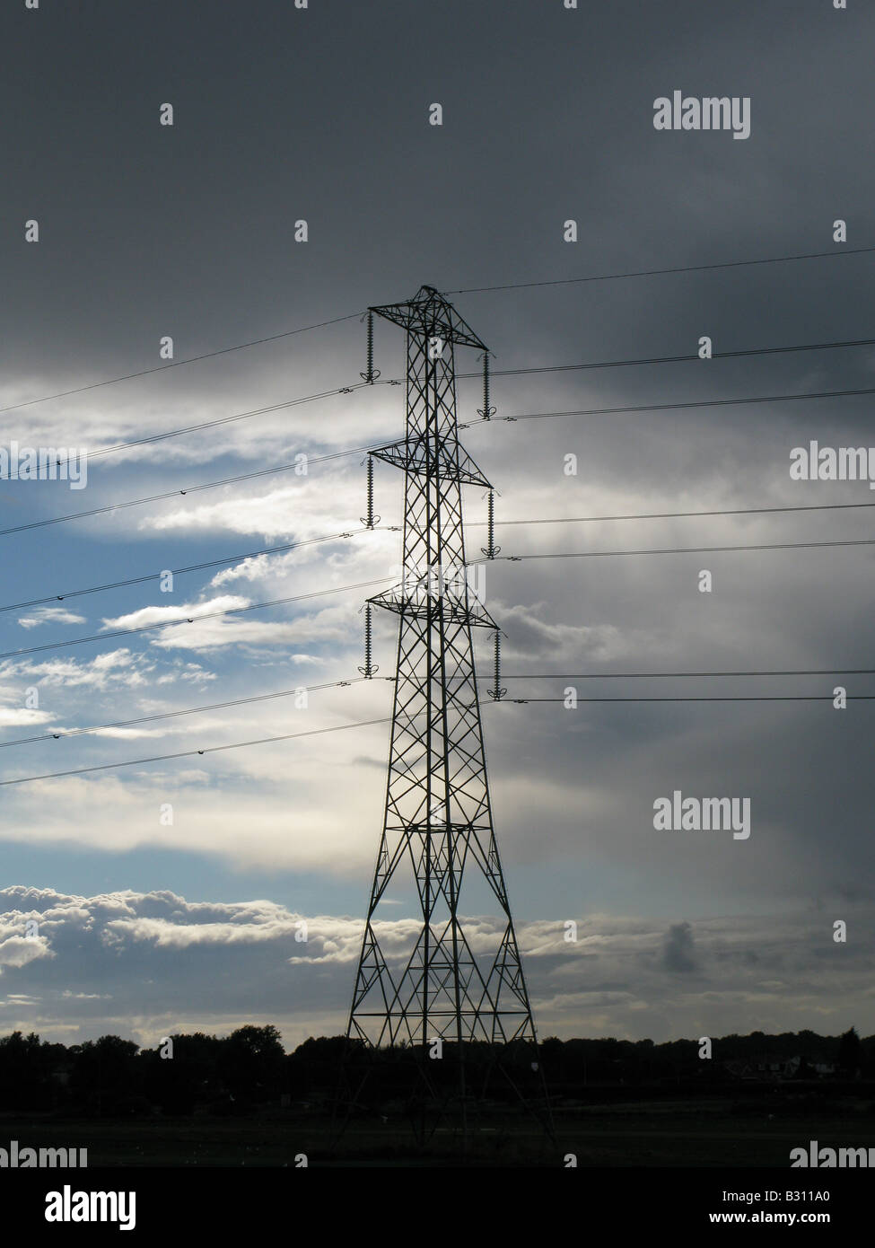 Electricity pylon with storm clouds and blue sky background Stock Photo ...