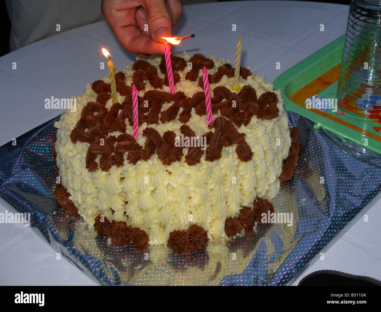 Lighting the candles on a birthday cake Stock Photo