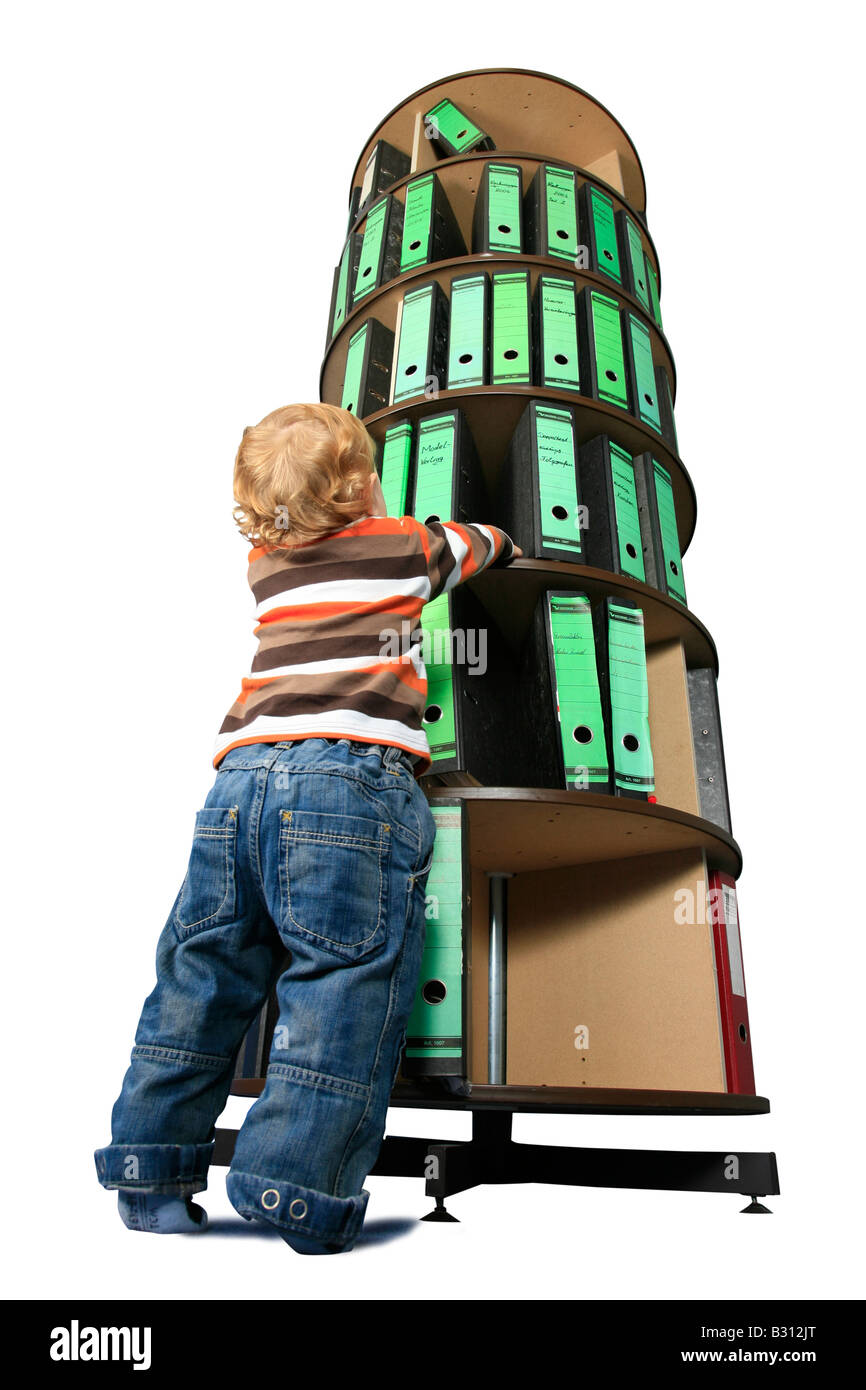 small boy in front of a folder storage rack Stock Photo