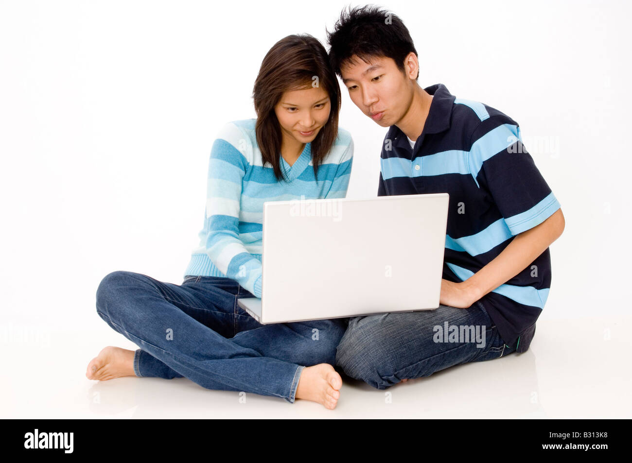 An asian couple sitting on the floor with their laptop Stock Photo - Alamy
