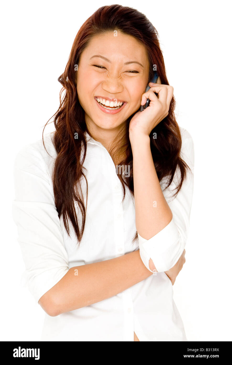 A pretty young asian woman laughs as she talks on a cellphone Stock