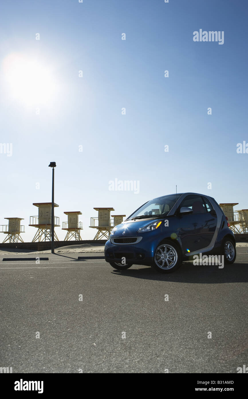 Smartcar parked by lifeguard stands at beach Stock Photo