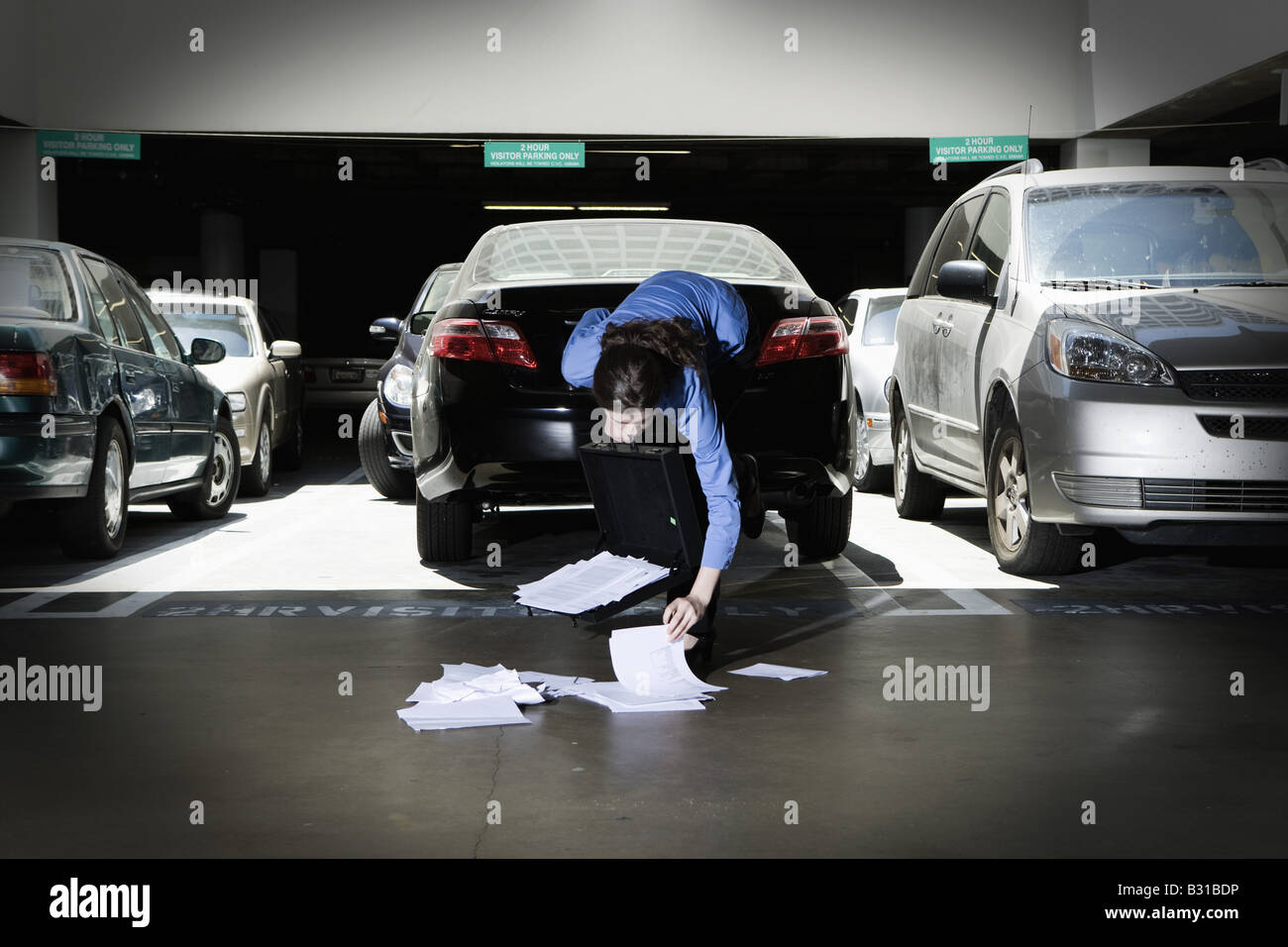 Young woman picking up dropped papers Stock Photo Alamy