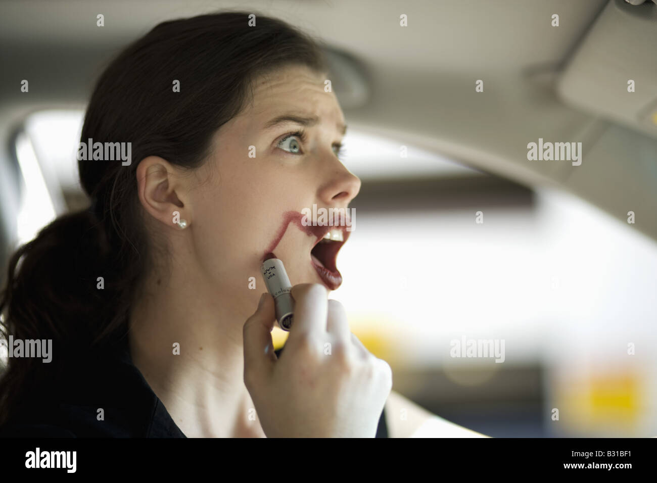 Young woman in car with smudged lipstick Stock Photo