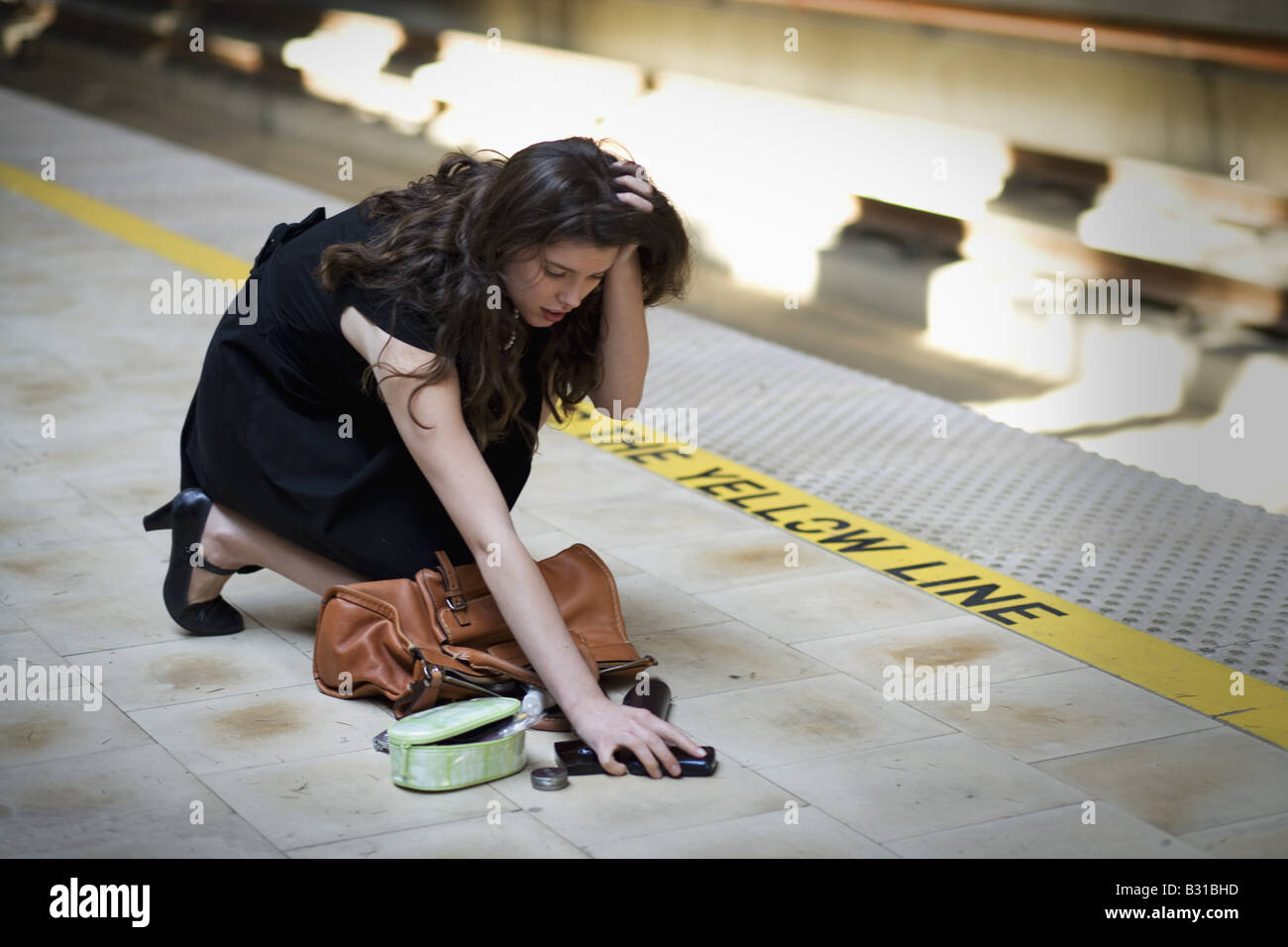 Young woman picking up spilled personal items from the floor Stock ...