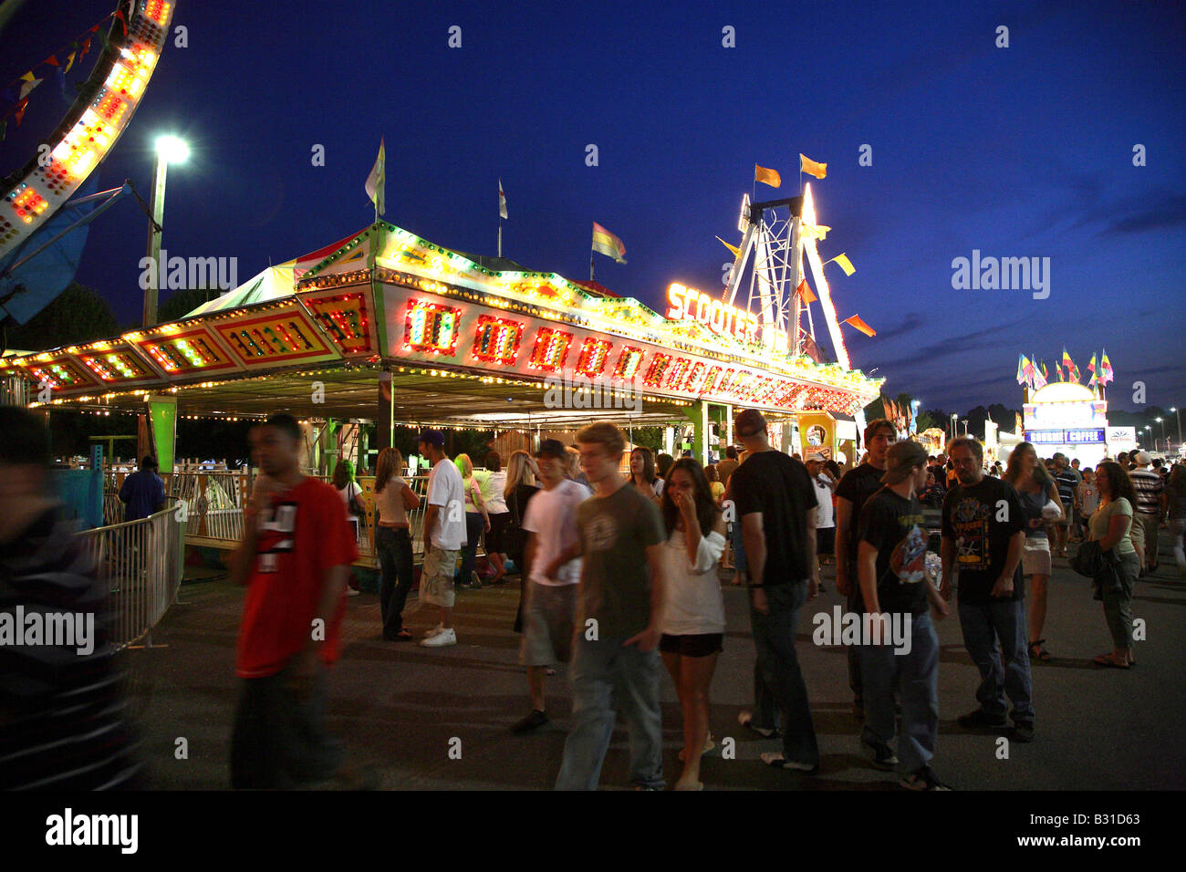 Bumper cars or scooters funfair ride from distance with mass of bright lights on top of square structure. Stock Photo