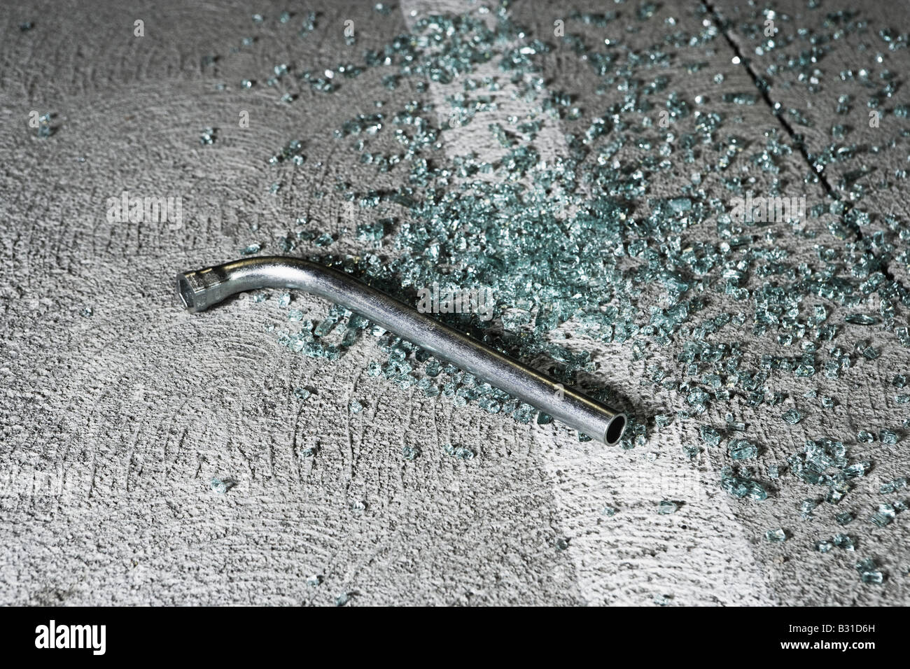 Crowbar and broken glass in car park Stock Photo