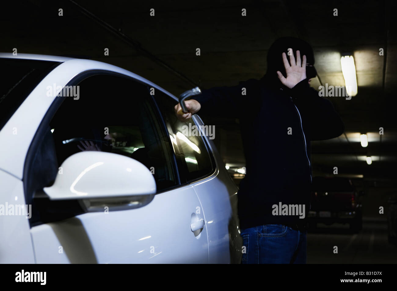 Thief breaking window of car with Crowbar Stock Photo Alamy