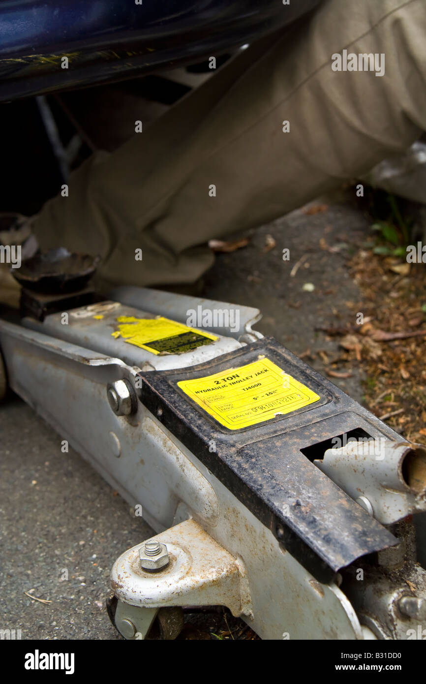 Close up trolley jack under car auto man mans leg uk hires stock