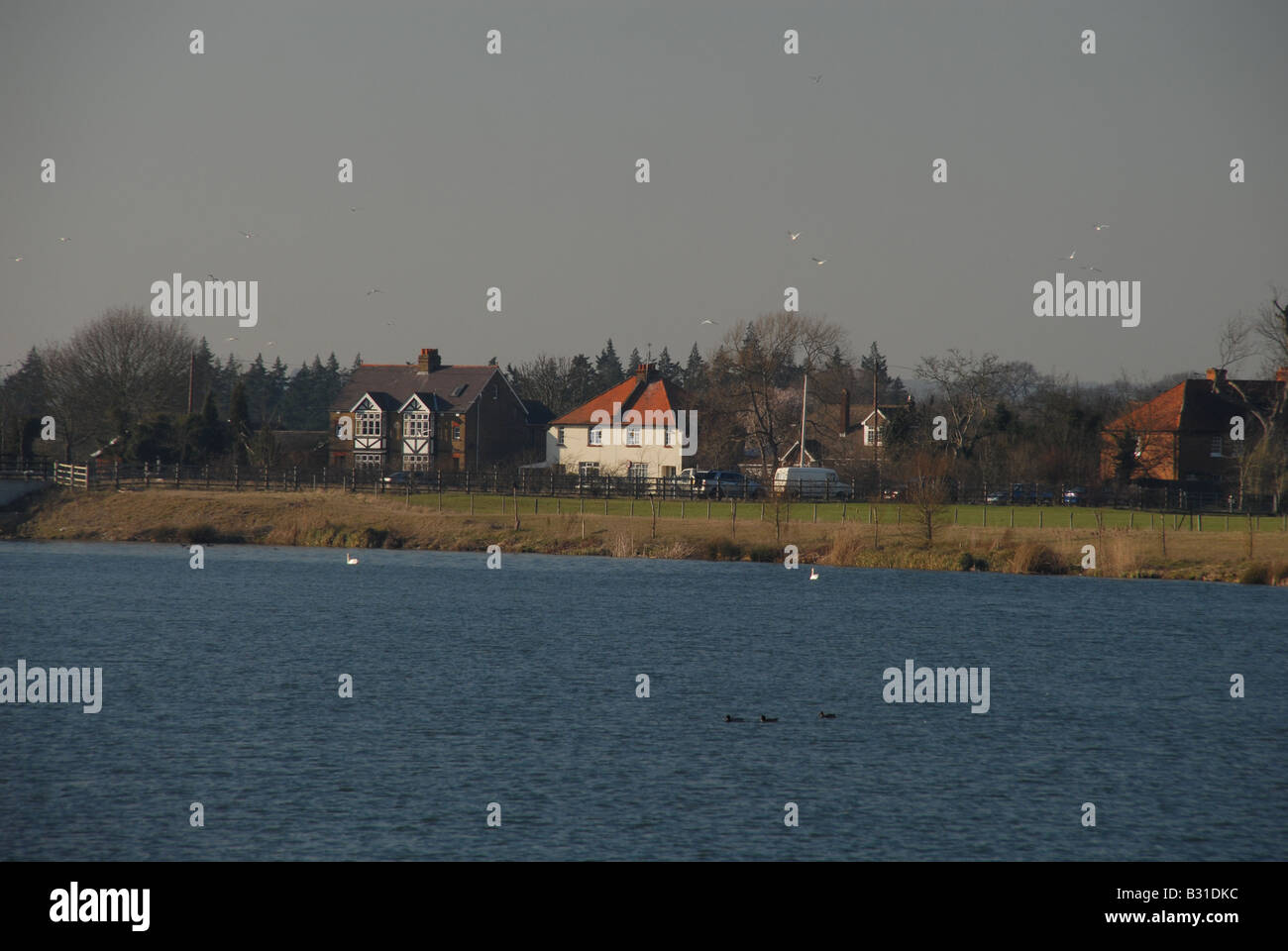 Cottages viewed across the Jubilee river near Windsor on a dark winter's day. Stock Photo