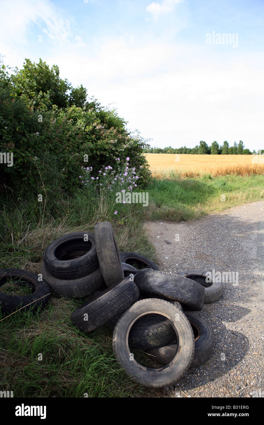 Fly Tipping A pile of old tyres left in the countryside in Suffolk East Anglia Stock Photo