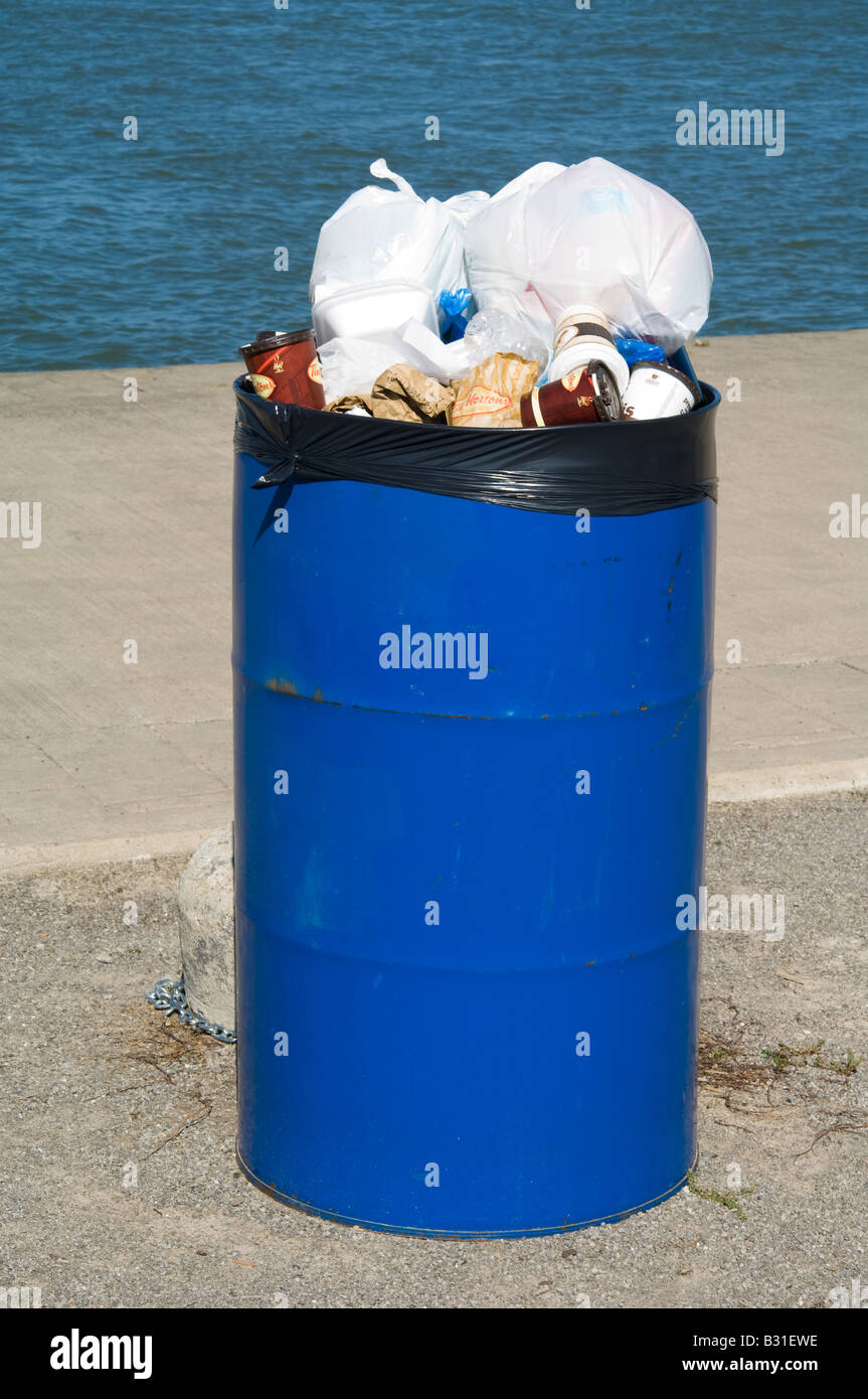A garbage can overflows with trash. Stock Photo
