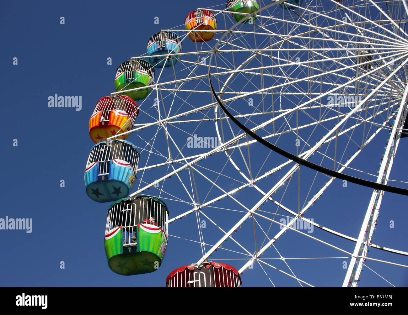FERRIS WHEEL AT FAIRGROUND AGAINST BRIGHT BLUE SKY HORIZONTAL BDA11261