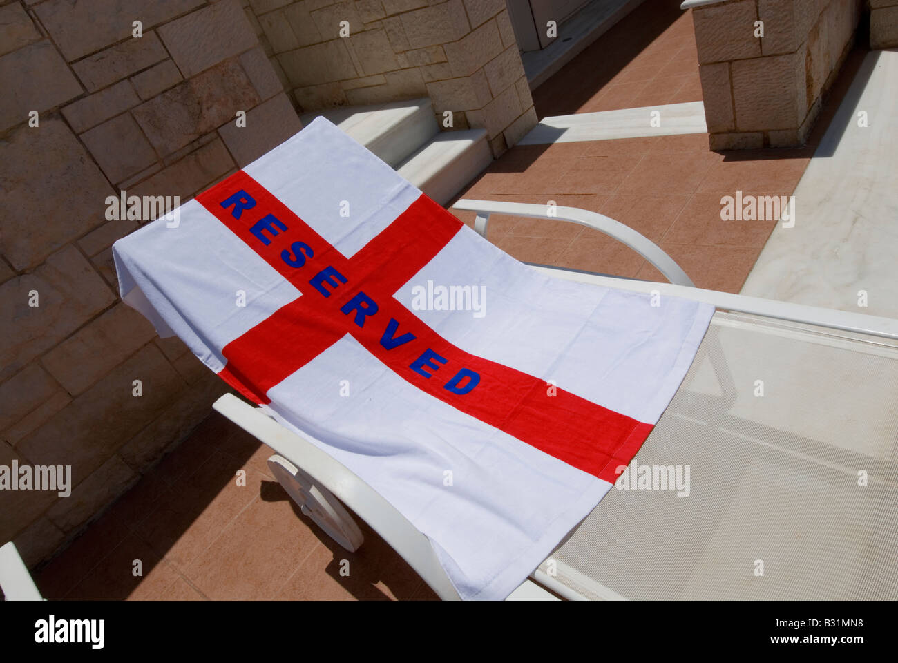 ‘'Reserved' towel pool chair with English Cross of St George flag fun on pool holiday sun-lounger Patriotism Jingoism Jingoistic Nationalism Brexit EU Stock Photo