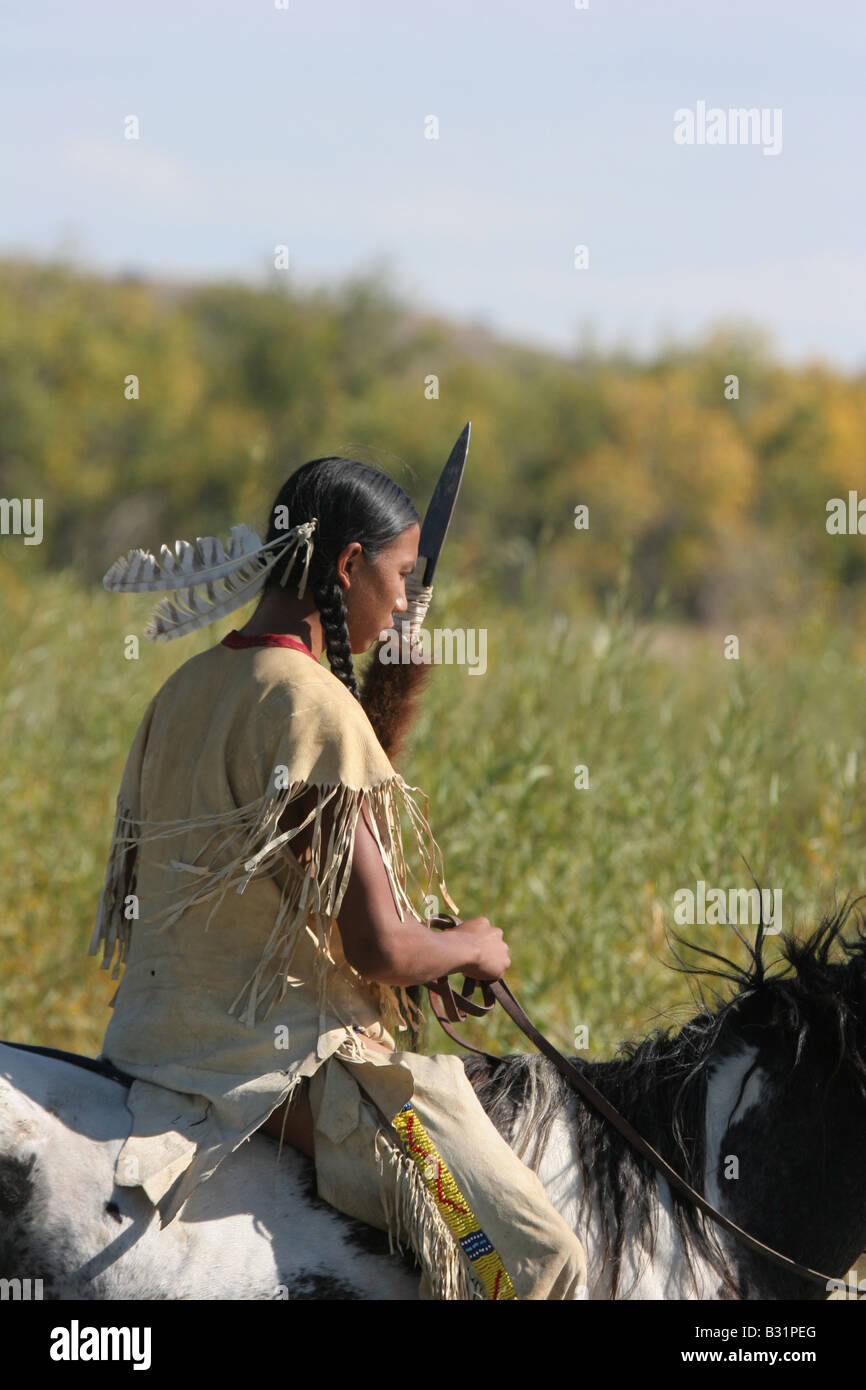 A Native American Sioux Indian boy on horseback riding across a stream in South Dakota Stock Photo