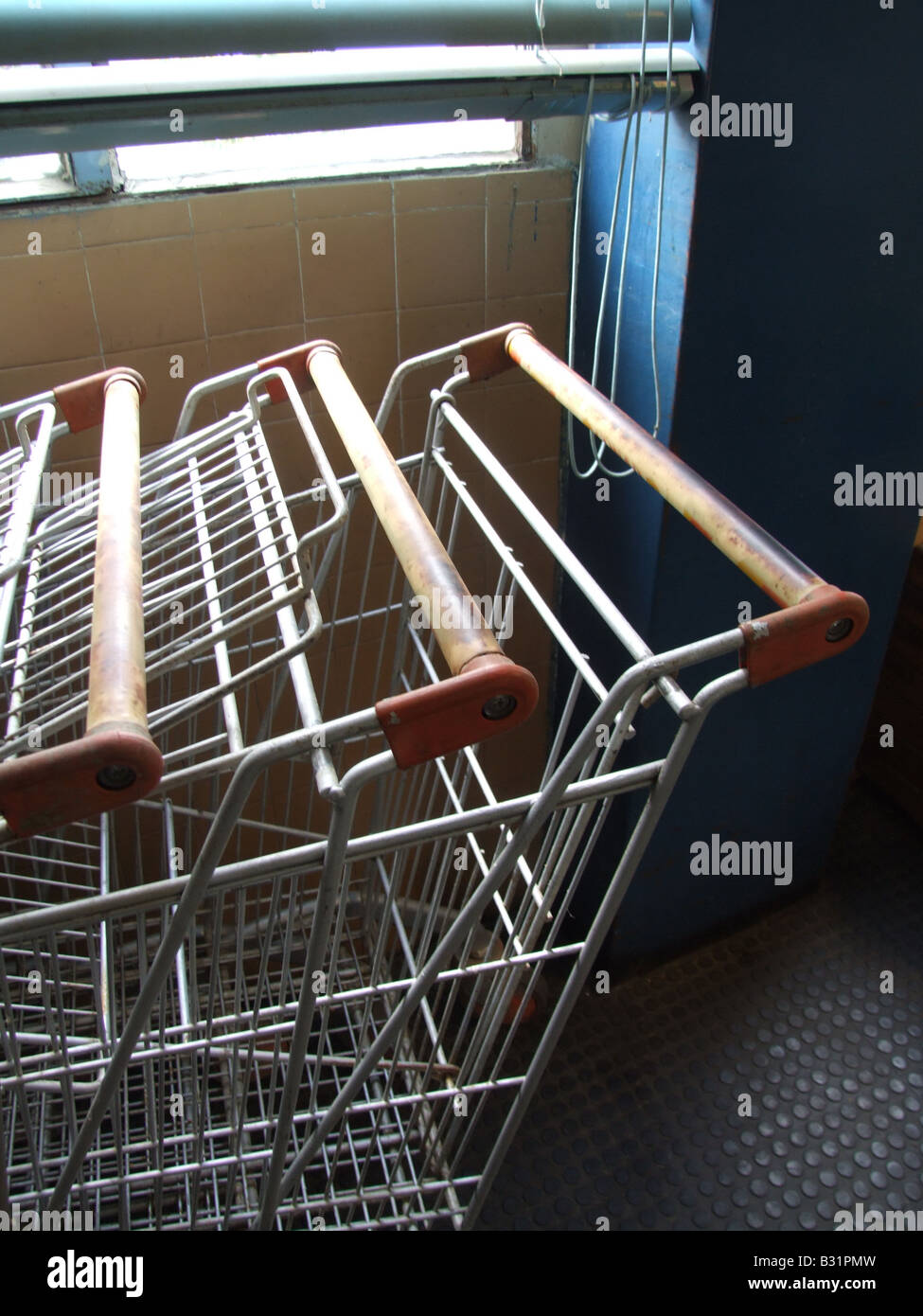 lots of old shopping trolleys at dark indoor market Stock Photo - Alamy