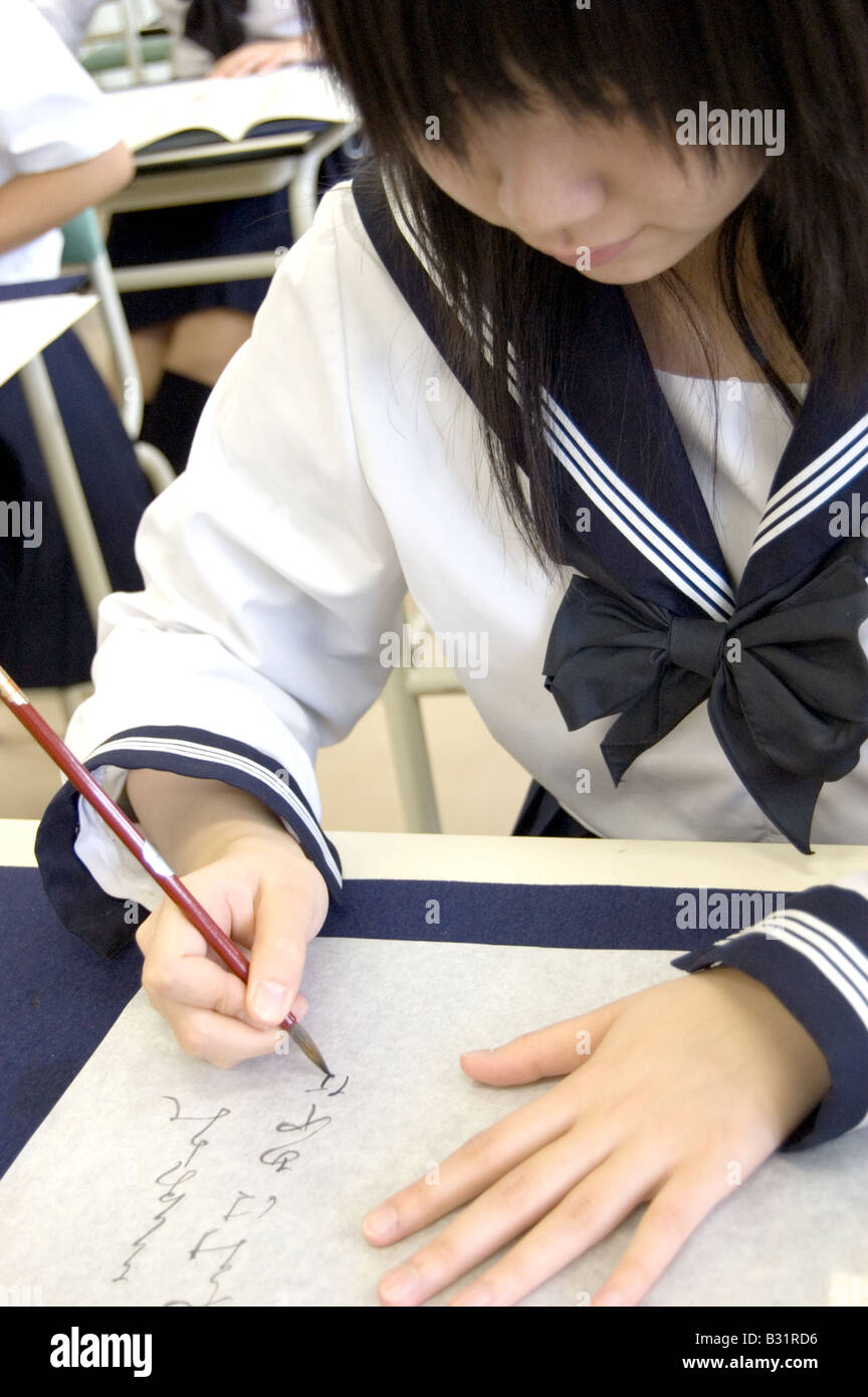 Advanced calligraphy student practicing in a japanese high school stock