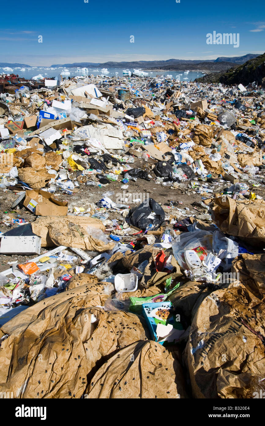 Ilulissat town rubbish dump with icebergs behind, Greenland Stock Photo