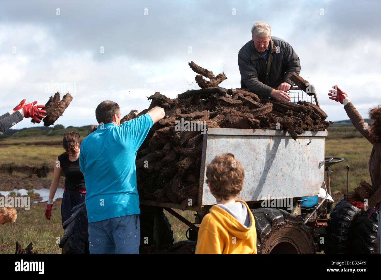 large extended irish family bringing home the turf peat fuel collection on home made transporter in easkey county sligo Stock Photo