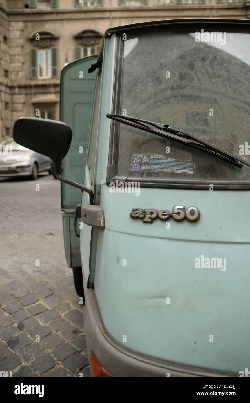 Piaggio Ape three-wheeled van parked in Via Del Pie'di Marmo, central Rome, Italy Stock Photo