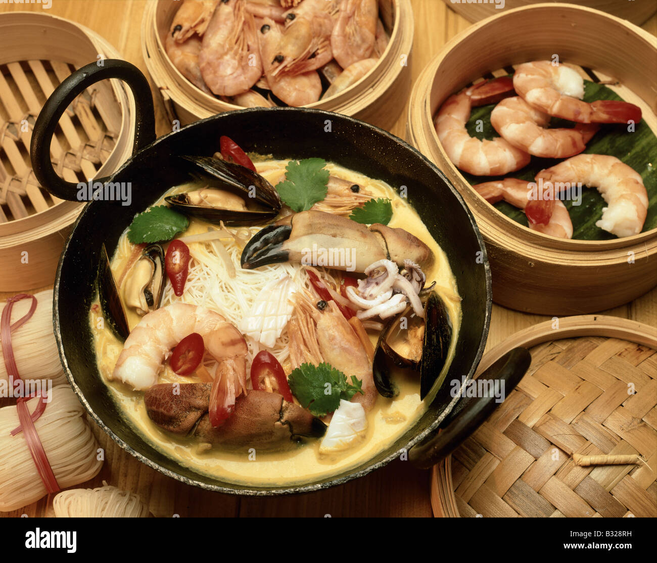 Nonya Malaysia Singapore Two handled wok Spicey seafood coconut soup dish Noodles Steam baskets SEAFOOD LAKSA SINGAPORE Stock Photo