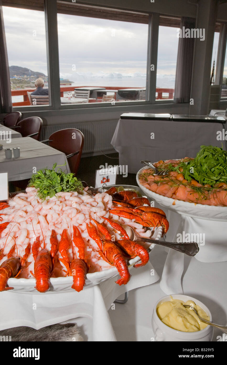 A Greenlandic seafood buffet in the Hotel Arctic in Ilulissat with icebergs from the ilulissat ice fjord behind Stock Photo