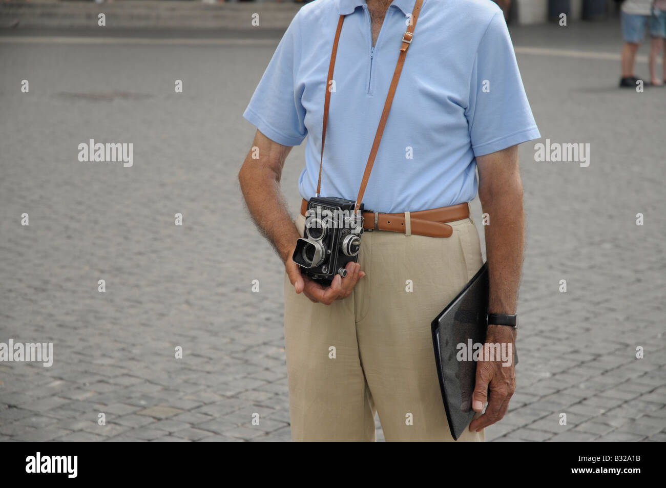 Man holding a vintage twin Lens Rolleiflex film camera at St Peters Square, Vatican, Rome, Italy Stock Photo